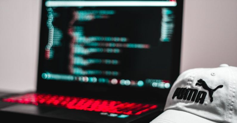 Coding - Black and Red Laptop Computer Beside White Puma Curve Brim Cap