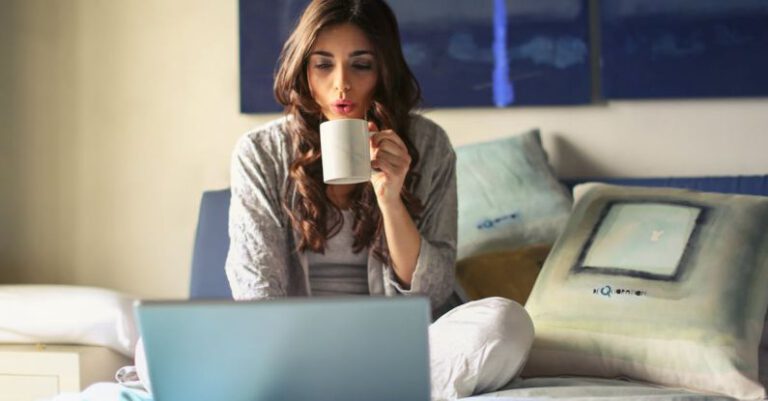 Pc - Woman in Grey Jacket Sits on Bed Uses Grey Laptop