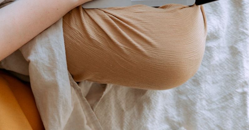 Data Validation - Anonymous woman in casual clothes sitting on sofa and browsing laptop with blank screen while working on project on bed