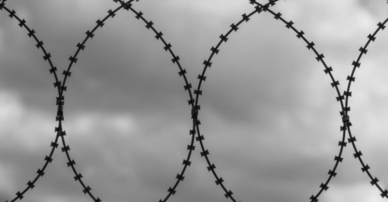 Security Audits - Close-up of a Barbed Wire on the Background of a Cloudy Sky