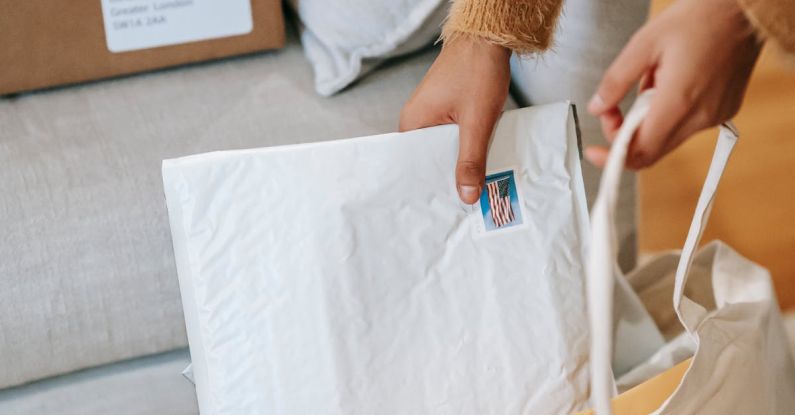 Postman - Crop faceless woman putting parcels into big bag