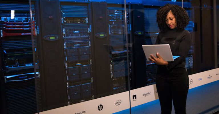 Database Migrations - Software Engineer Standing Beside Server Racks